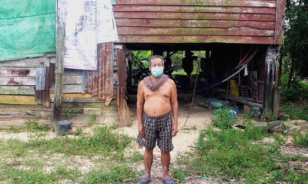 Chao Sob, 62, stands in front of his house, a resettlement house built by Union Development Group, which he says is deteriorating, in Koh Kong province's Kiri Sakor district on June 28, 2021. (Danielle Keeton-Olsen/VOD)
