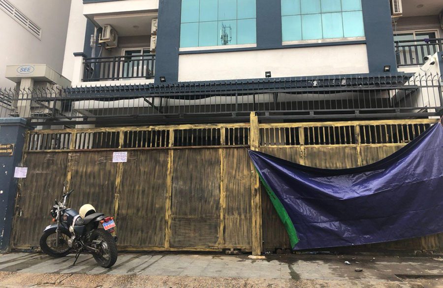 A motorbike with army plates and a tarp sit in front the gate of a condominium where military police arrested more than 100 people in Phnom Penh's Phsar Doeum Thkov commune on August 23, 2021. (Mech Dara/VOD)