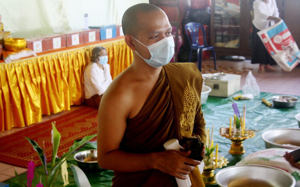 Mony Chat Tith at Phnom Penh’s Wat Svay Pope wears a mask and carries disinfectant spray, on September 22, 2021. (Michael Dickison/VOD)