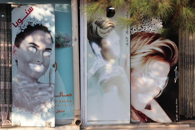 Images of women on a beauty salon in the Afghan capital Kabul are seen painted over in a photo taken September 2021. (Thomson Reuters Foundation)
