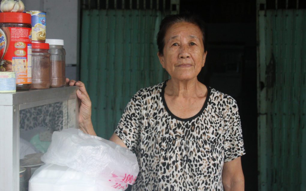 Hour Pov, 70, sells drinks at the ground floor of an abandoned school building on Phnom Penh’s Street 144, on October 15, 2021. (Michael Dickison/VOD)