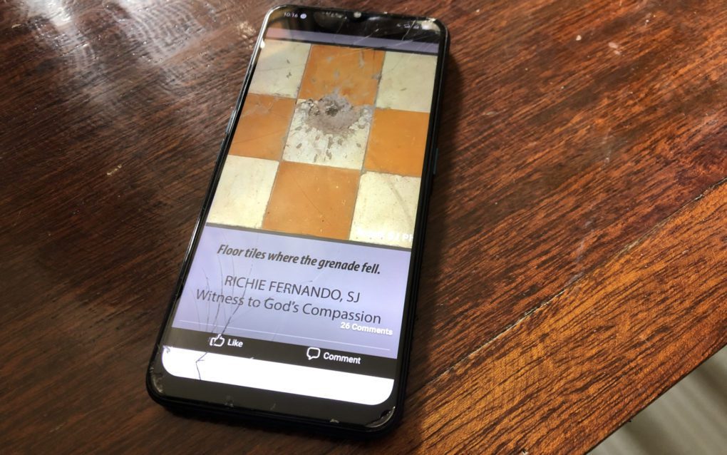 Men Yuth, a former teacher at Banteay Prieb vocational school, shows photos of Brother Richie Fernando and the floor tiles marked by the grenade blast on his phone, on September 28, 2021. (Matt Surrusco/VOD)