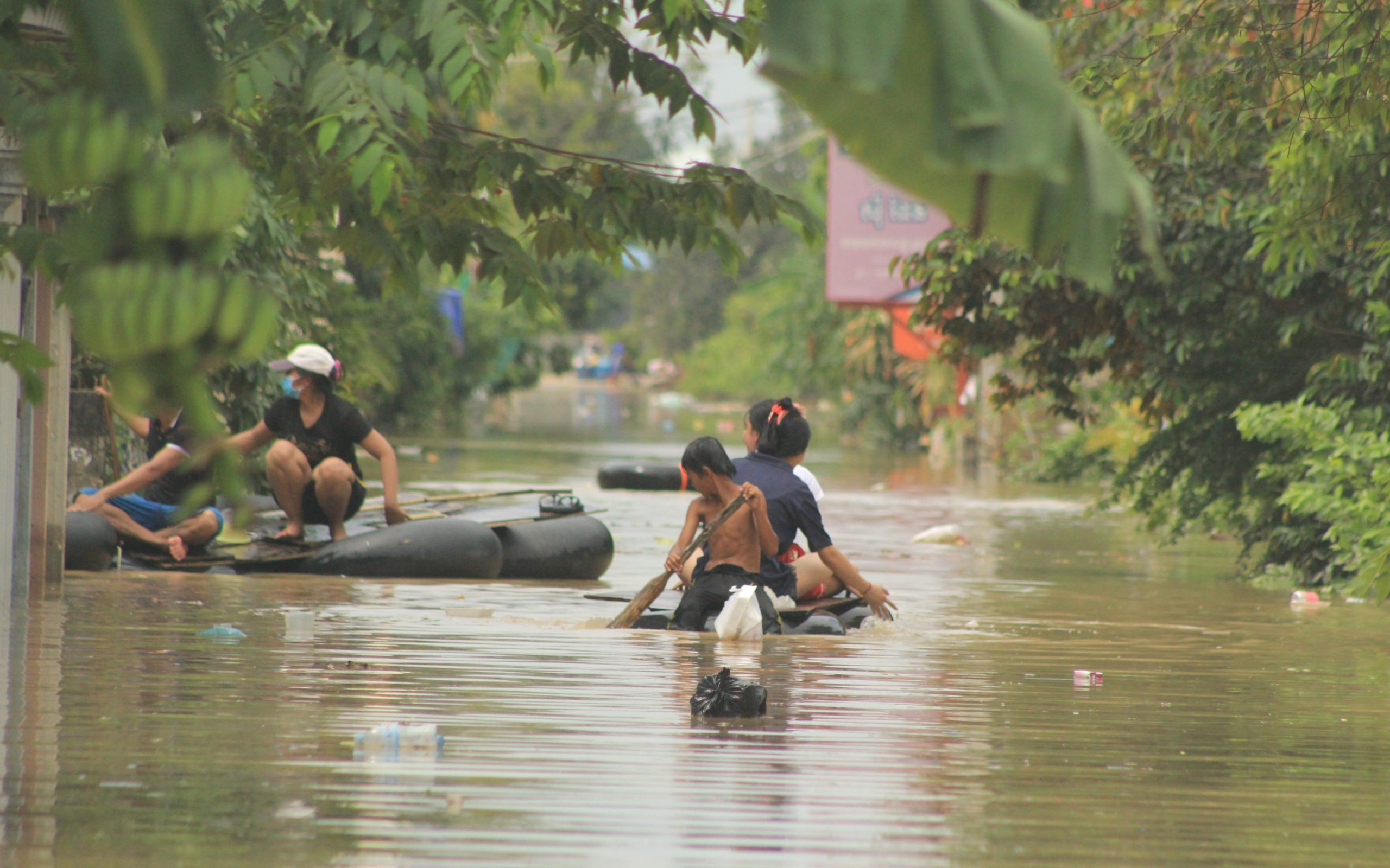 People paddle along flooded roads in Phnom Penh’s Dangkao district on October 28, 2021. (Andrew Haffner/VOD)