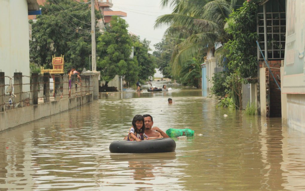 Families float along flooded roads in Phnom Penh’s Dangkao district on October 28, 2021. (Andrew Haffner/VOD)