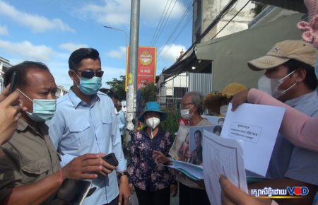 Officials view petitions and posters held by people protesting the new Phnom Penh airport development at Prime Minister Hun Sen's mansion in Takhmao city on November 16, 2021. (Chorn Chanren/VOD)