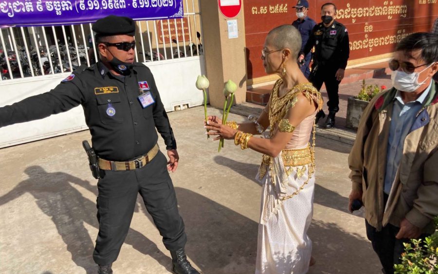 Seng Chantheary tries to give a flower to an officer outside the Phnom Penh Municipal Court on December 7, 2021. (Ananth Baliga/VOD)
