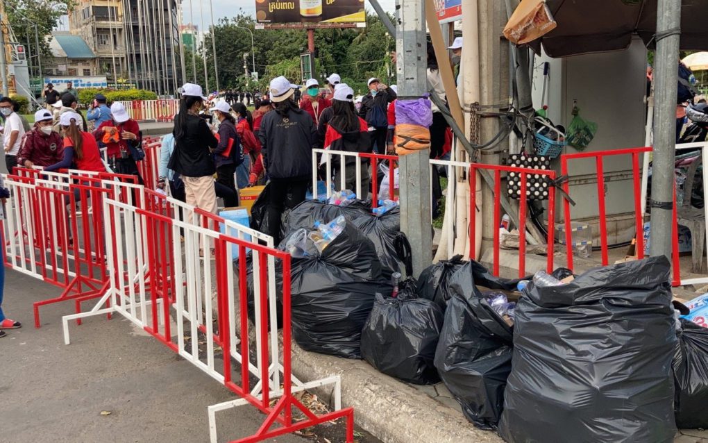 Nagaworld strike participants collect trash into black plastic bags after the strike ended in Tonle Bassac district on December 19, 2021. (Ananth Baliga/VOD)