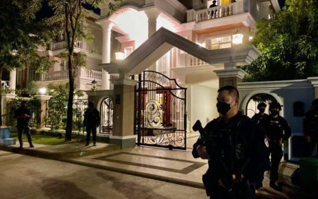 An armed military police guard stands in front of a house where 12 people including Khmer Rise Party president William Guang were arrested on Sunday, in a photo posted by Phnom Penh Military Police on December 20, 2021. (Facebook)