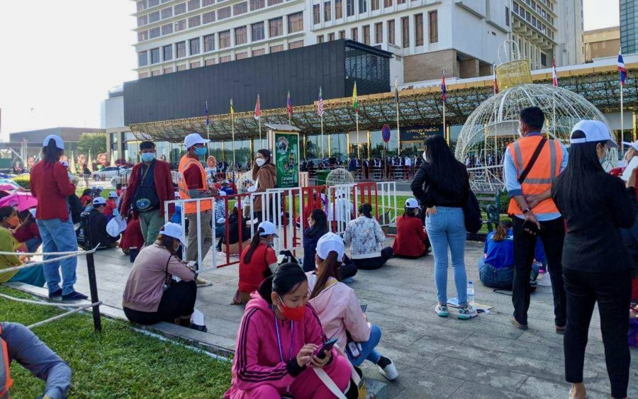 Members of the NagaWorld union sit outside a barricade at the park in front of the casino complex, saying they request more space on the fourth day of their labor strike on December 21, 2021. (Keat Soriththeavy/VOD)