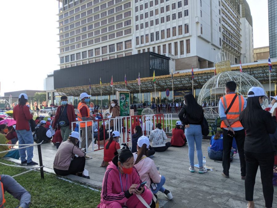 Members of the NagaWorld union sit outside a barricade at the park in front of the casino complex, saying they request more space on the fourth day of their labor strike on December 21, 2021. (Keat Soriththeavy/VOD)