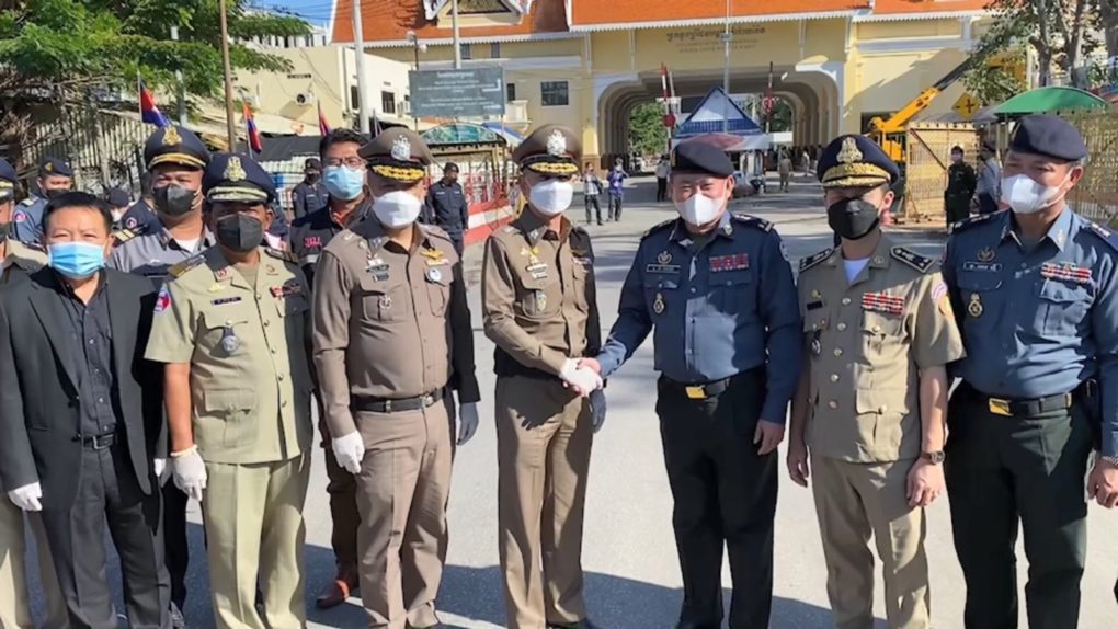 Thai authorities pose with two Cambodian officials at the Poipet border gate on November 24, 2021. (Royal Thai Police)