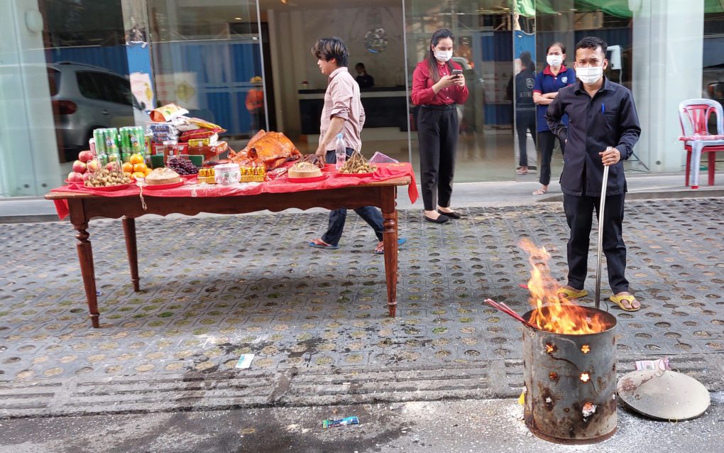 A security guard tends a Lunar New Year offering and fire outside the Bellavita condo in Phnom Penh's Boeng Keng Kang district on January 31, 2022. (Danielle Keeton-Olsen/VOD)