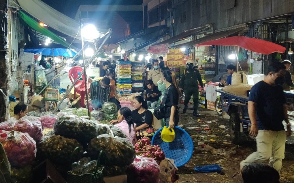Police and other officials check on vegetable sellers on a side road off Mao Tse Toung Blvd early morning March 9, 2022. (Michael Dickison/VOD)