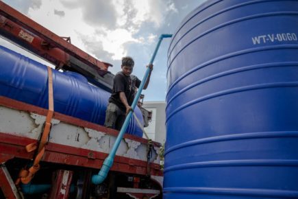 A water tank is refilled at Phnom Penh’s Borey Piphup Thmey on March 22, 2022. (Roun Ry/VOD)