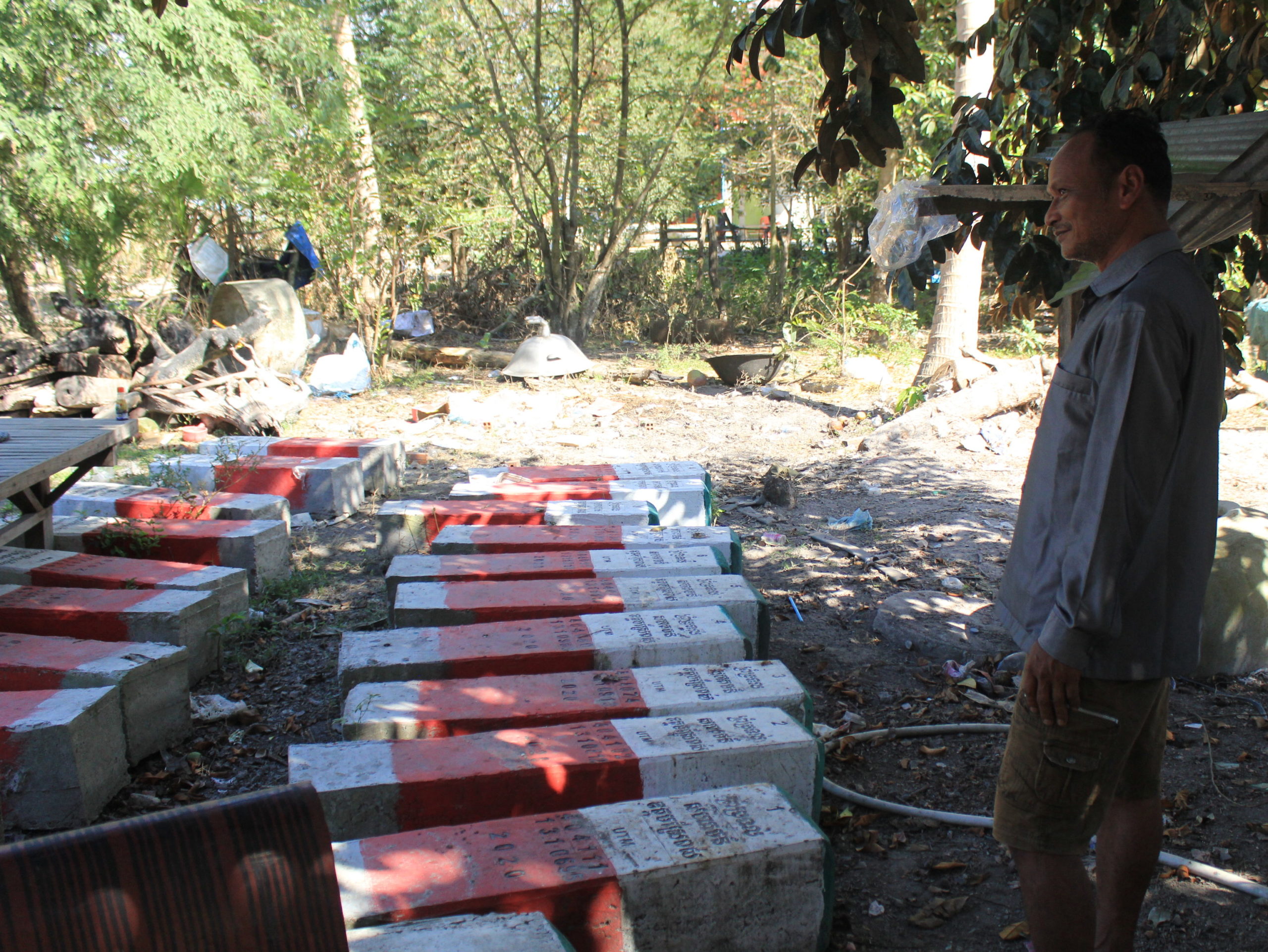 Pou Meas villager Chhuon Khoeun stands before concrete posts he says were made to demarcate the local community forest as part of its formalization with environmental officials. That process ground to an unexplained halt in 2020, villagers say. (Andrew Haffner/VOD)