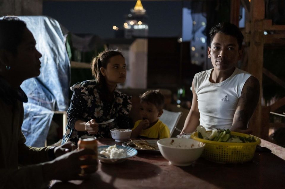 Construction worker Ma Srieng and his wife Som Theary eat dinner on the third floor of a half-built 18-storey condominium in central Phnom Penh with their 2-year-old son. Like many construction workers in Phnom Penh, they migrated to the capital seeking work. (Andy Ball)