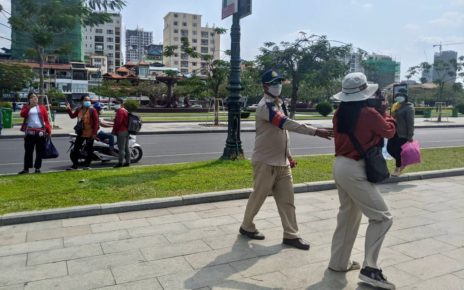 A district security guard blocks a journalist covering the NagaWorld casino labor dispute on March 15, 2022.