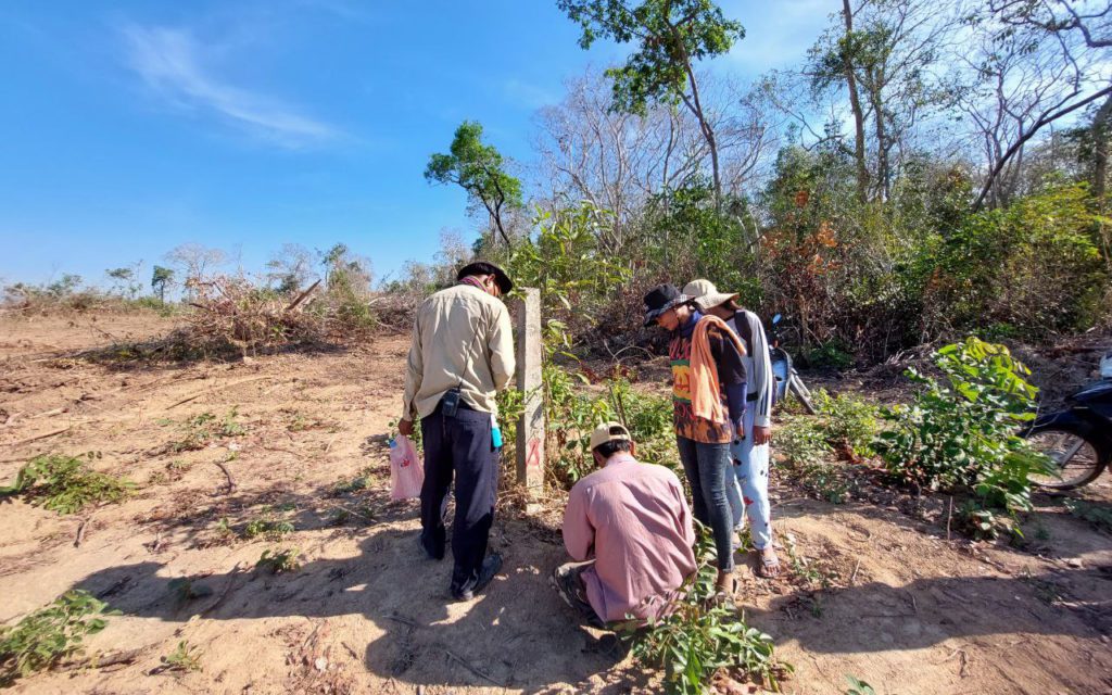 Koh Entchey community forest patrollers inspect a pole placed in the brush in Kratie province in February 2022. (Keat Soriththeavy/VOD)