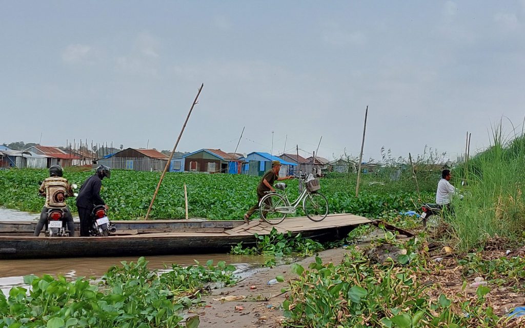 A man loads a bicycle and other vehicles off a ferry running between the floating communities on the Tonle Sap in Phnom Penh's Prek Pnov district on March 15, 2022. (Danielle Keeton-Olsen/VOD) 
