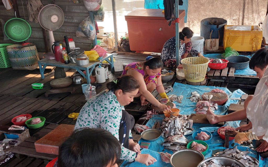 A family debones and renders fish for making meatballs on a Tonle Sap river houseboat in Phnom Penh's Prek Pnov district on March 15, 2022. (Danielle Keeton-Olsen/VOD)