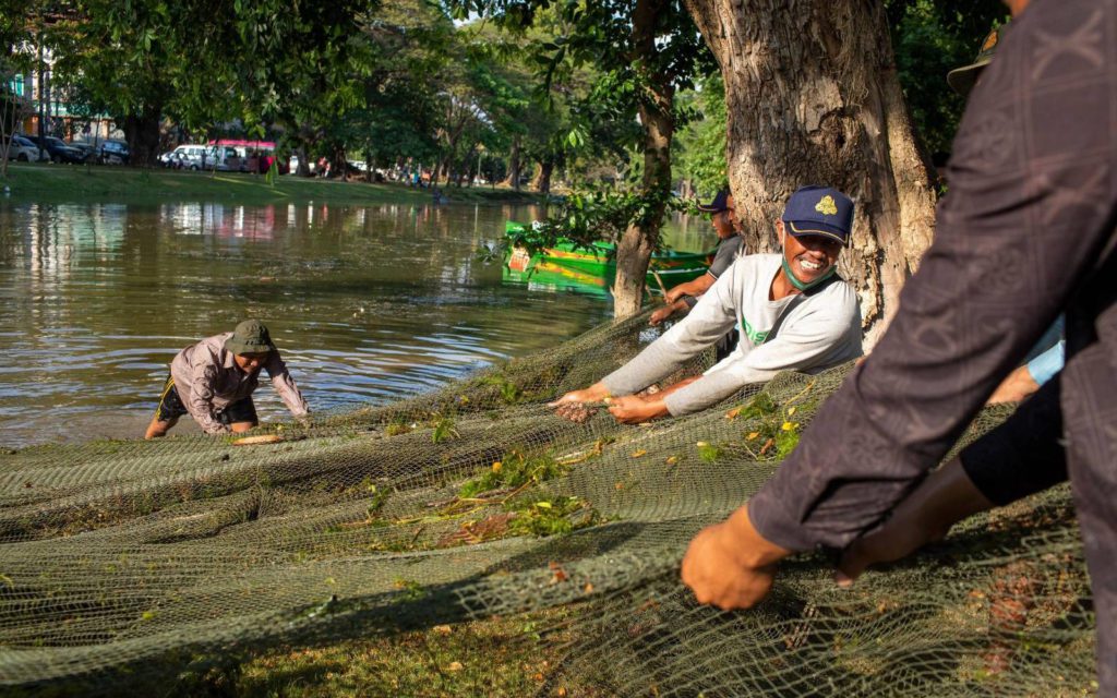 Workers pull nets to dredge debris out of the Siem Reap river in preparation for the Sangkran festival on March 31, 2022. (Roun Ry/VOD)