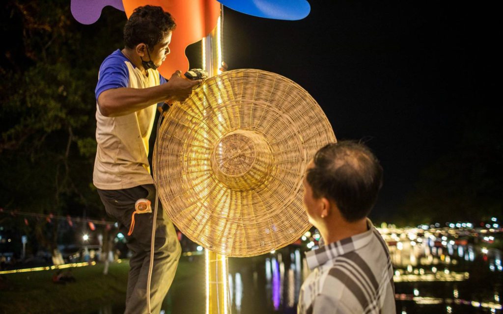 A man drills a straw hat onto a pole in order to decorate for the upcoming Sangkran festival in Siem Reap on March 30, 2022. (Roun Ry/VOD)