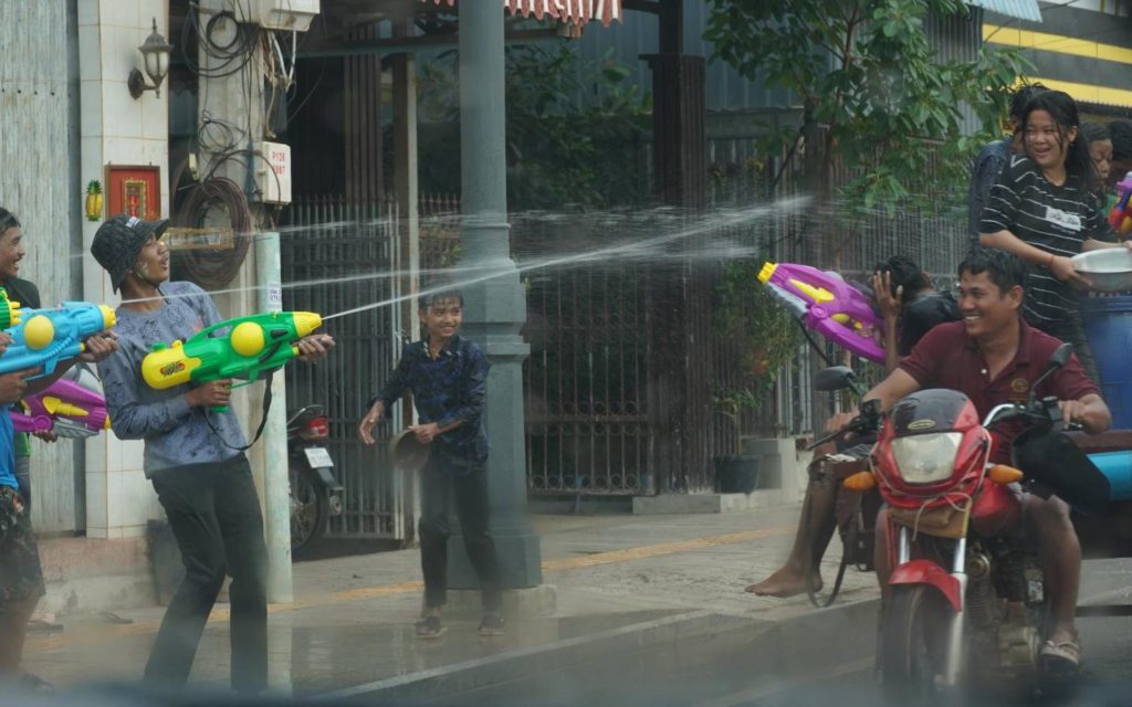 A group of young people spray each other from the road and trailer-bikes during the Khmer New Year celebration in Siem Reap on April 16, 2022. (Tran Techseng/VOD)