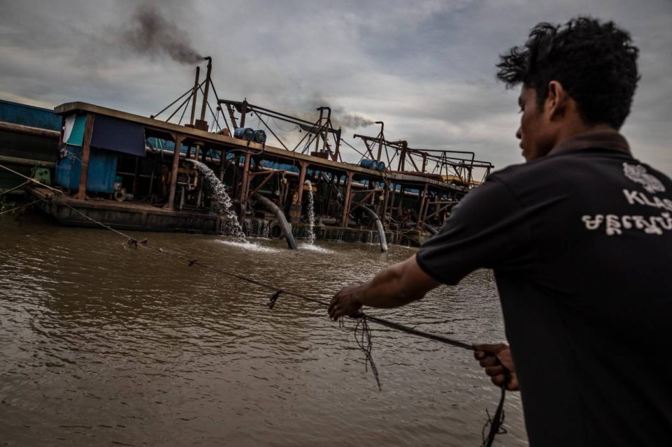 A sand dredging worker uses a rope to pull his raft toward a sand pumping station in Phnom Penh on May 11, 2022. (Roun Ry/VOD)