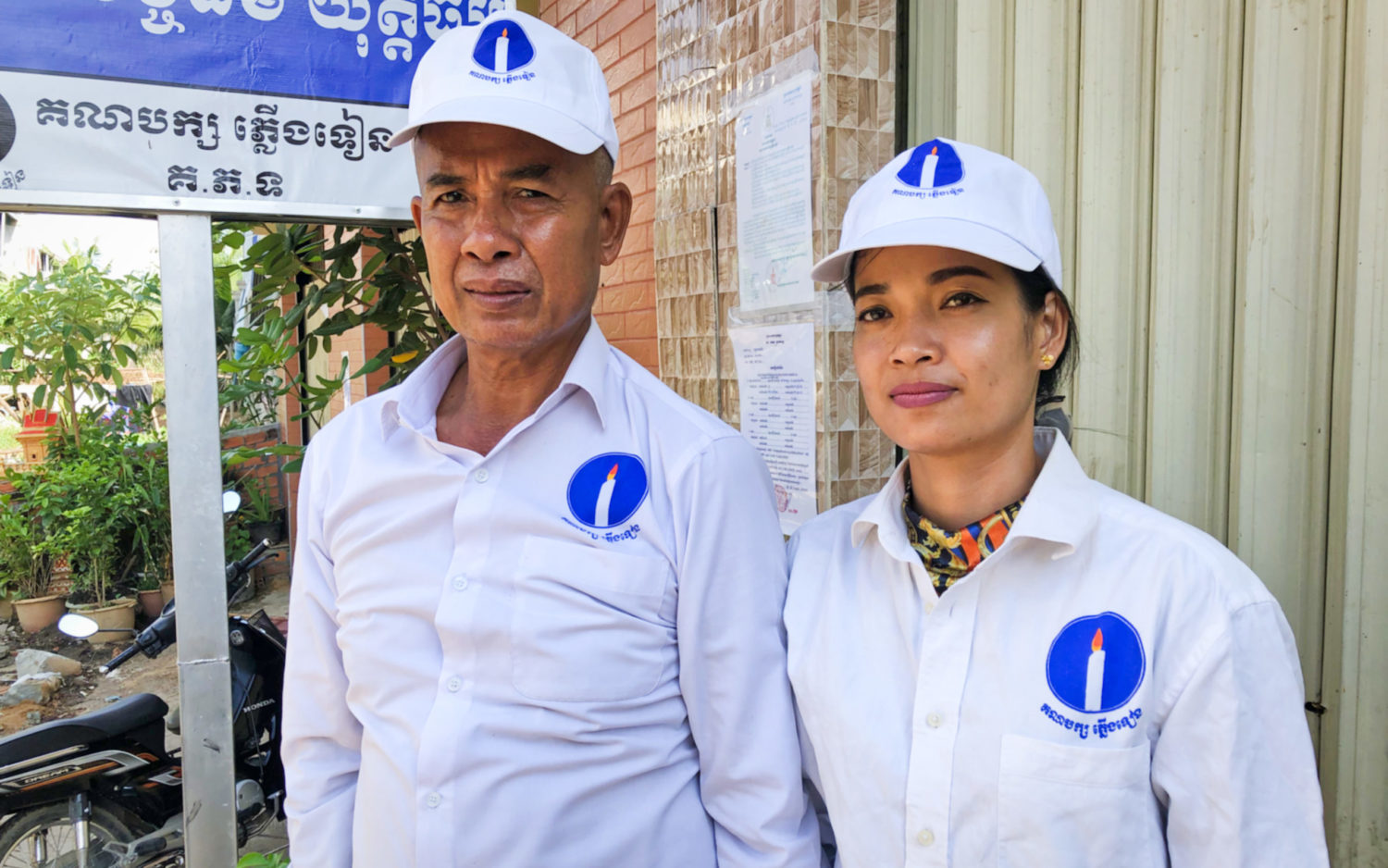 Chao Ratanak, Candlelight Party’s commune chief candidate in Poipet commune, stands next to her father, Chao Veasna, a former opposition councilor in the commune, outside her house on May 14, 2022. (Matt Surrusco/VOD)