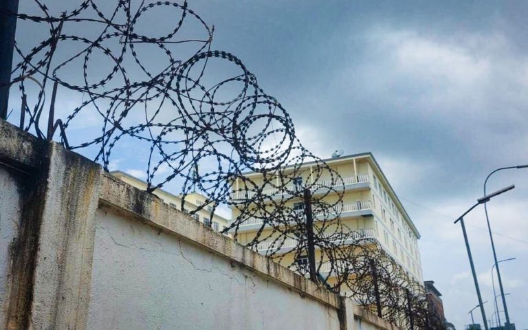 The barbed wire fence surrounding a building complex, called "Jincai" by one worker, where workers are allegedly detained to perpetuate scams, on May 30, 2022. (Danielle Keeton-Olsen/VOD)