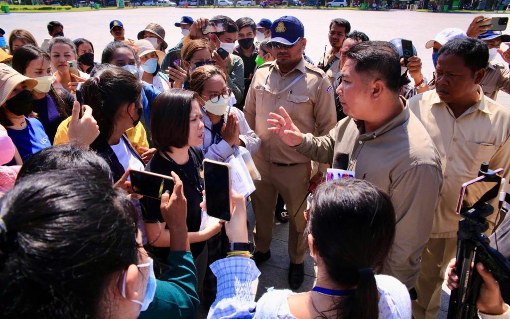 Union leader Chhim Sithar speaks to a local official at Wat Botum park on June 20, 2022.