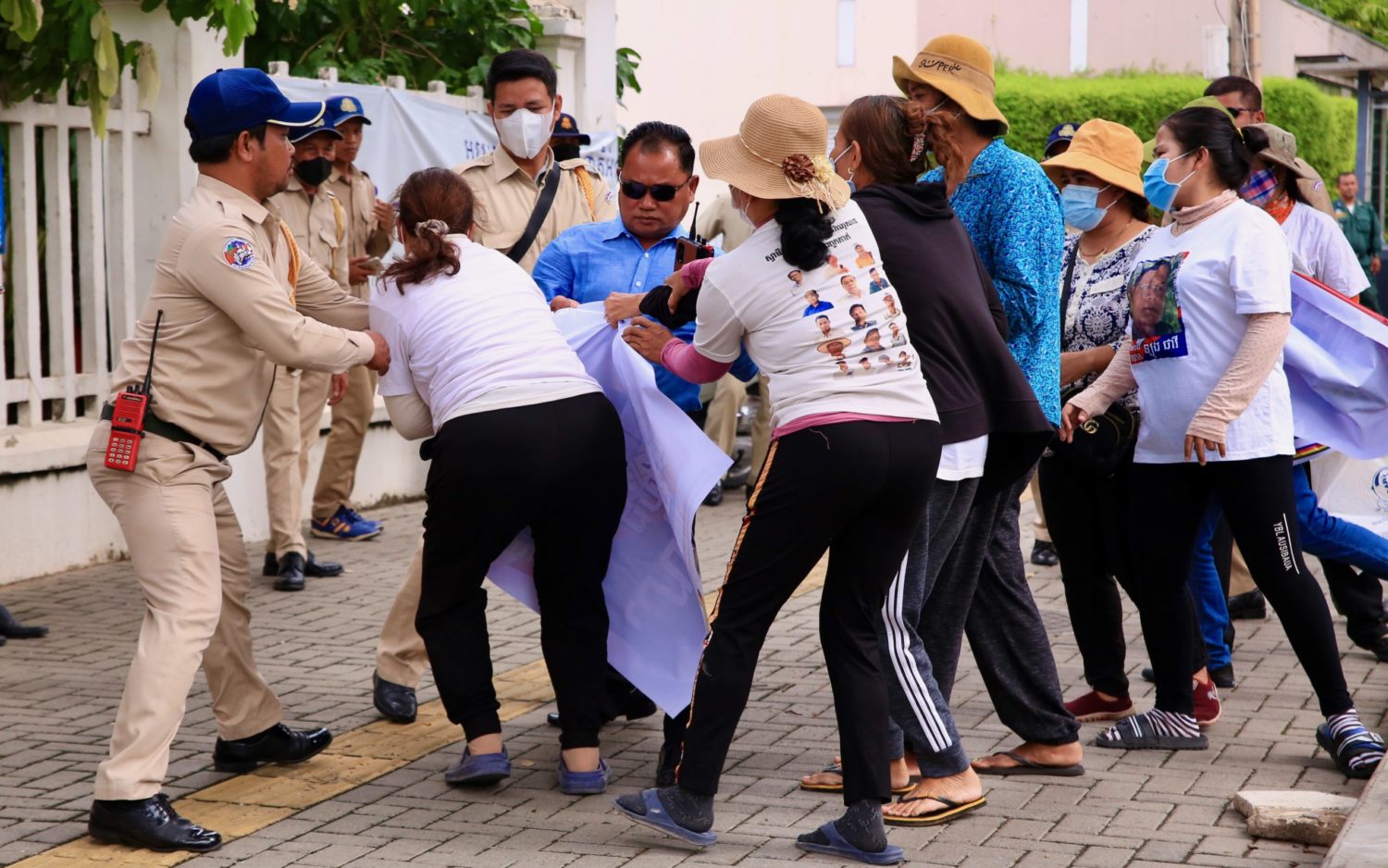 Daun Penh authorities pull banners held Friday Women protesters on July 1, 2022.