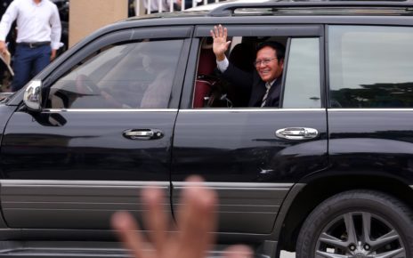 Kem Sokha waves to his supporters as he leaves the Phnom Penh Municipal Court on July 13, 2022.
