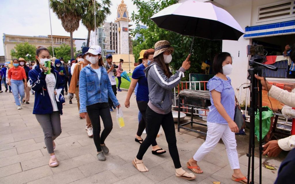 NagaWorld workers walk to Hun Sen's cabinet office at Wat Botum park on July 1, 2022.