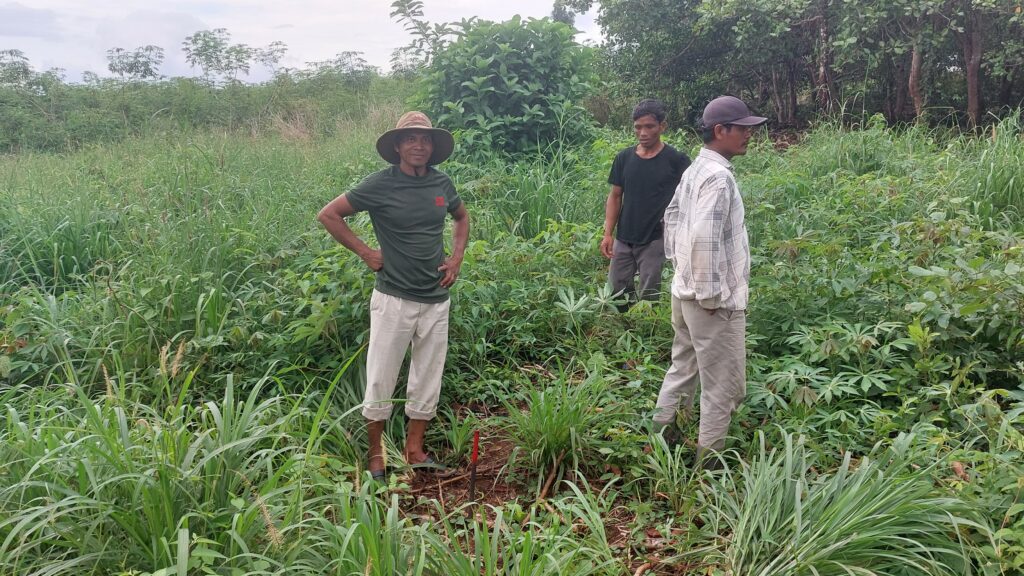 Toal Community Protected Area chief Mao Nov (left) and members of the CPA patrol stand near a thin iron pole placed by Electricite du Cambodge to mark a new transmission line's path, in Stung Treng's Anlong Phe commune on May 18, 2022. (Danielle Keeton-Olsen/VOD)