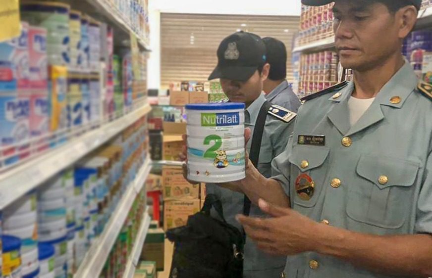 Consumer protection officers inspect a can of Nutrilatt in Poipet in September 2020. (Consumer Protection, Competition and Fraud department)