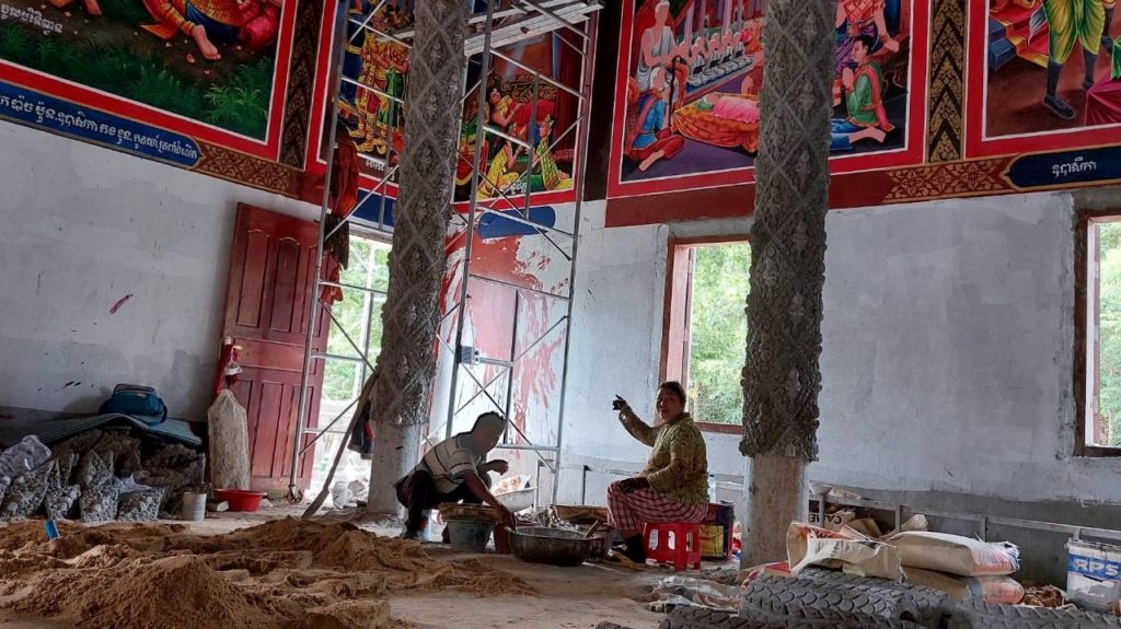 Two artisans fill sand into molds to redecorate Phnom Tamao pagoda in Takeo province on August 5, 2022. (Danielle Keeton-Olsen/VOD)