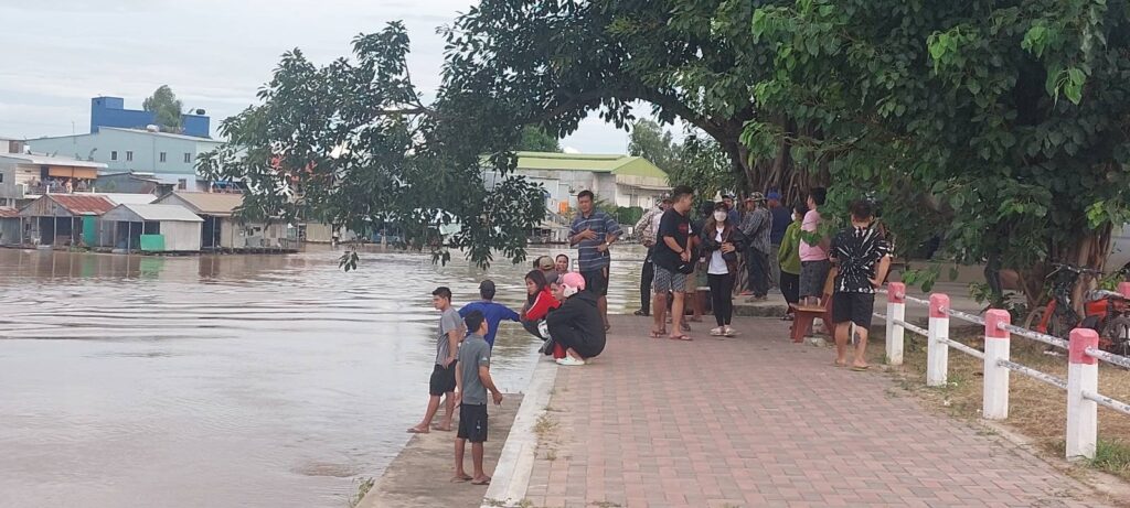 People gather at the riverside near the Pacific Real Estate buildin after more than 40 workers escaped, in Kandal province's Sampov Poun commune on August 18, 2022. (Danielle Keeton-Olsen/VOD)
