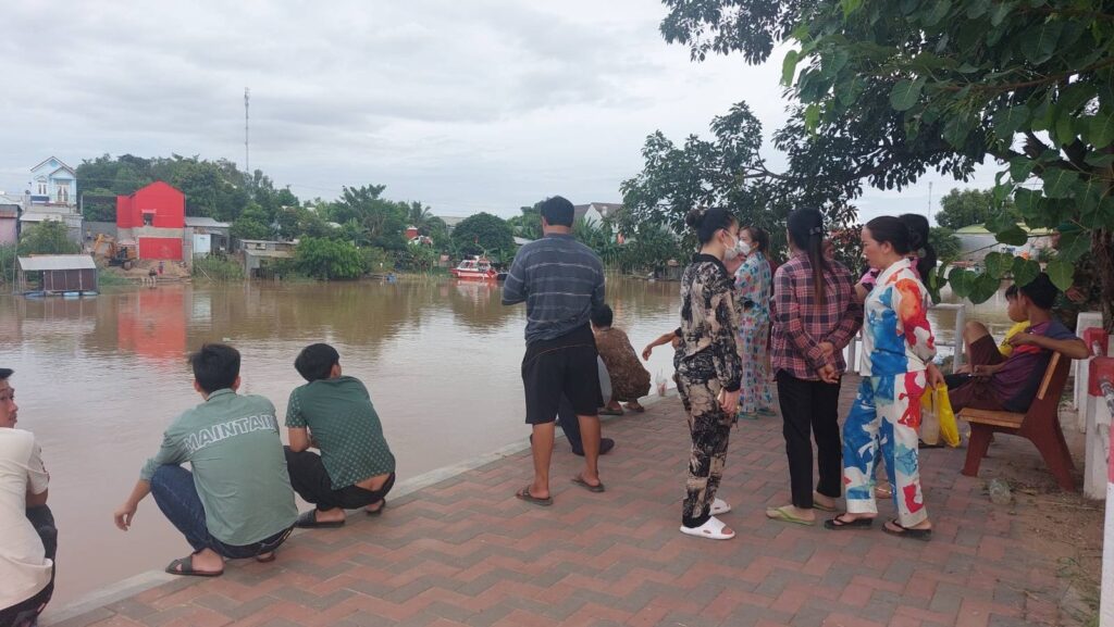 People gather at the riverside near the Pacific Real Estate buildin after more than 40 workers escaped, in Kandal province's Sampov Poun commune on August 18, 2022. (Danielle Keeton-Olsen/VOD)