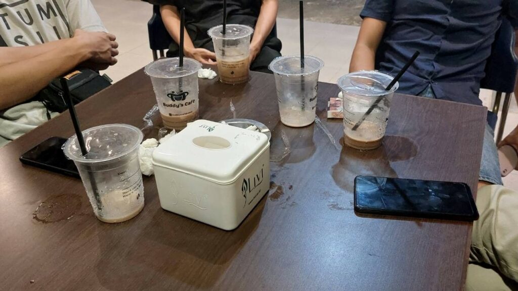 A group of Indonesian citizens who were rescued from a Cambodian scam operation drink iced coffee and tea in a cafe in Batam city on July 15, 2022. (Danielle Keeton-Olsen/VOD)