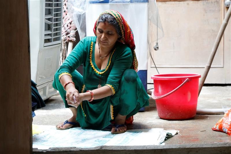 Ritu, who suffered two miscarriages over the last year in an attempt to have a son, washes clothes in her village home in Hisar, India, July 31, 2022. (Thomson Reuters Foundation/Annie Banerji)