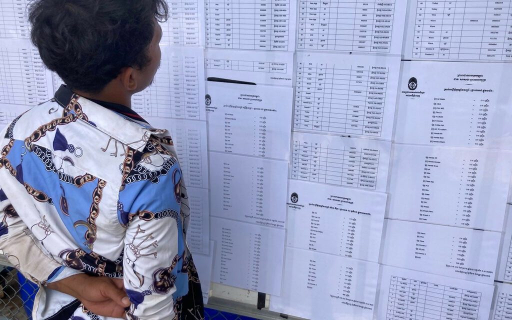 A man looks for his motorbike on lists of vehicles confiscated from illegal pawnshops, in Phnom Penh’s Chroy Changva district on October 3, 2022. (Ananth Baliga/VOD)