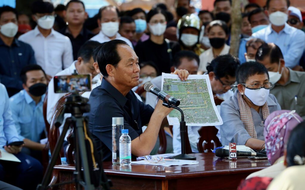 Land Minister Chea Sophara holds up a map at a meeting with Preah Dak residents. (Hean Rangsey/VOD)