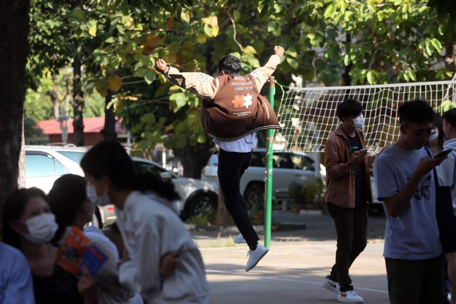 A student jumps in the air after the national exam results are posted at Phnom Penh's Sisowath High School on December 22, 2022. (Hean Rangsey/VOD)