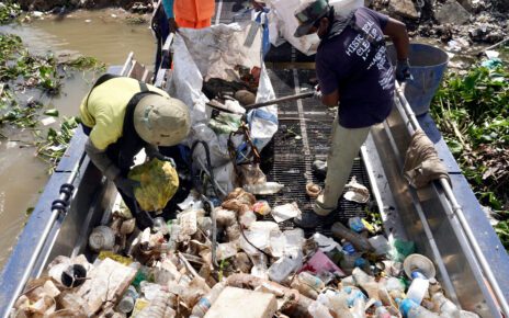 Staff sift through trash collected by the boat in Phnom Penh's Chbar Ampov district. (Hean Rangsey/VOD)