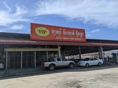 Two vehicles park in front of an empty storefront for Borey VIP, a defunct development owned by R.N. VIP Real Estate, in Phnom Penh's Dangkao district on January 4, 2023. (Keat Soriththeavy/VOD)