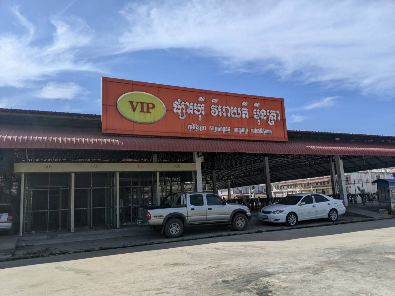 Two vehicles park in front of an empty storefront for Borey VIP, a defunct development owned by R.N. VIP Real Estate, in Phnom Penh's Dangkao district on January 4, 2023. (Keat Soriththeavy/VOD)