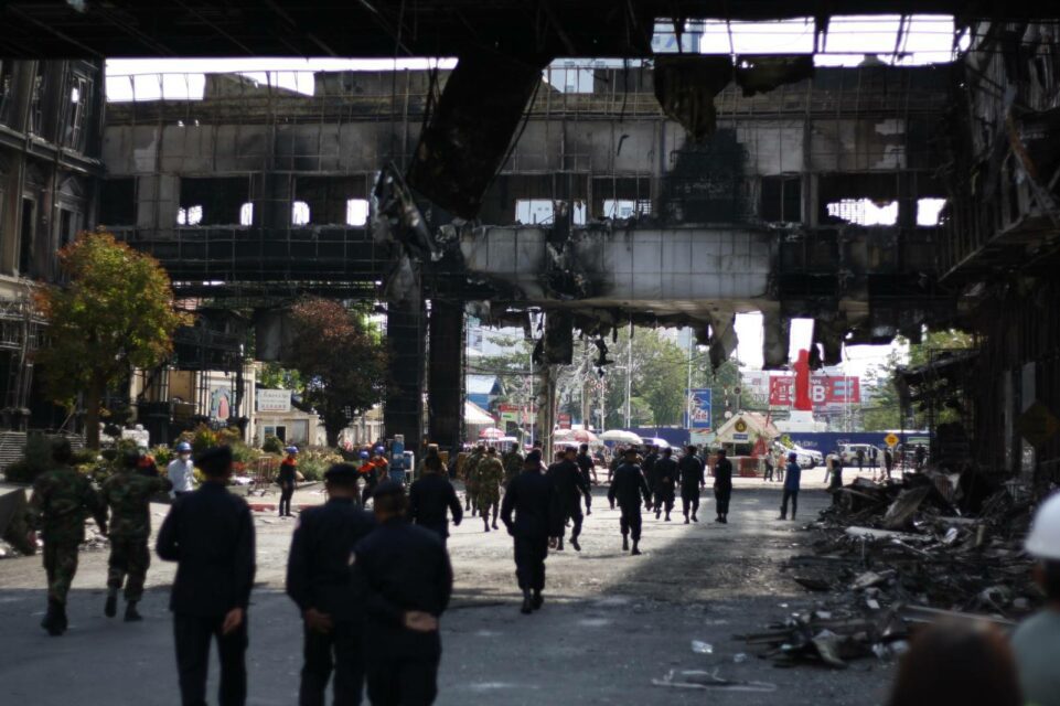 Officers walk outside the burnt down Grand Diamond Casino in Poipet city on December 31, 2022. (Michael Dickison/VOD)