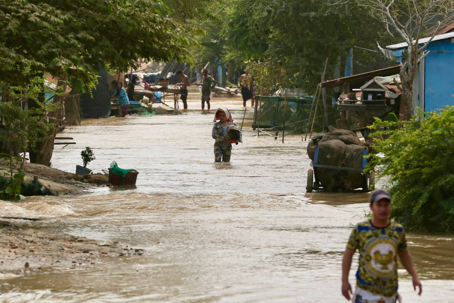Residents wade through flood waters from Prek Tnaut river in Kandal province. (Hean Rangsey)