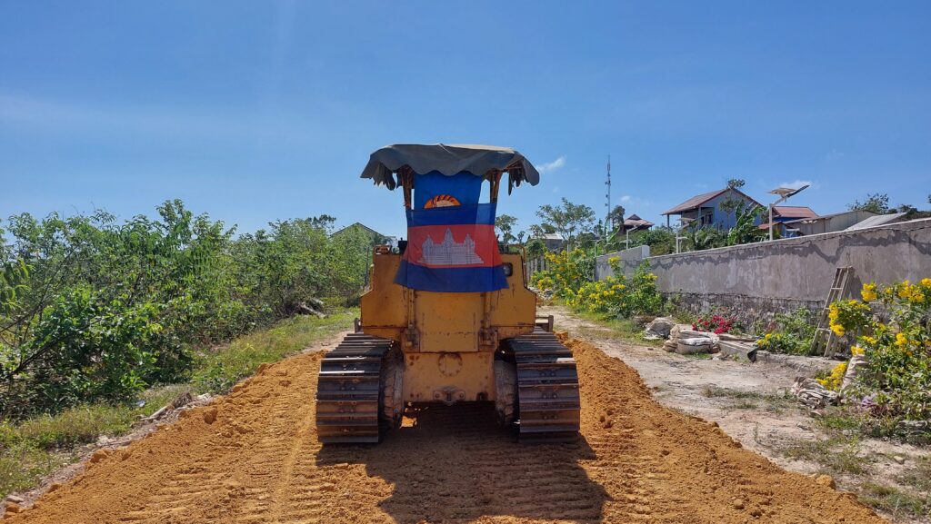 A tractor with Cambodian and CPP flags parked on a new road in Koh Rong Sanloem island's M'pei Bei village on February 5, 2023. (Danielle Keeton-Olsen/VOD)